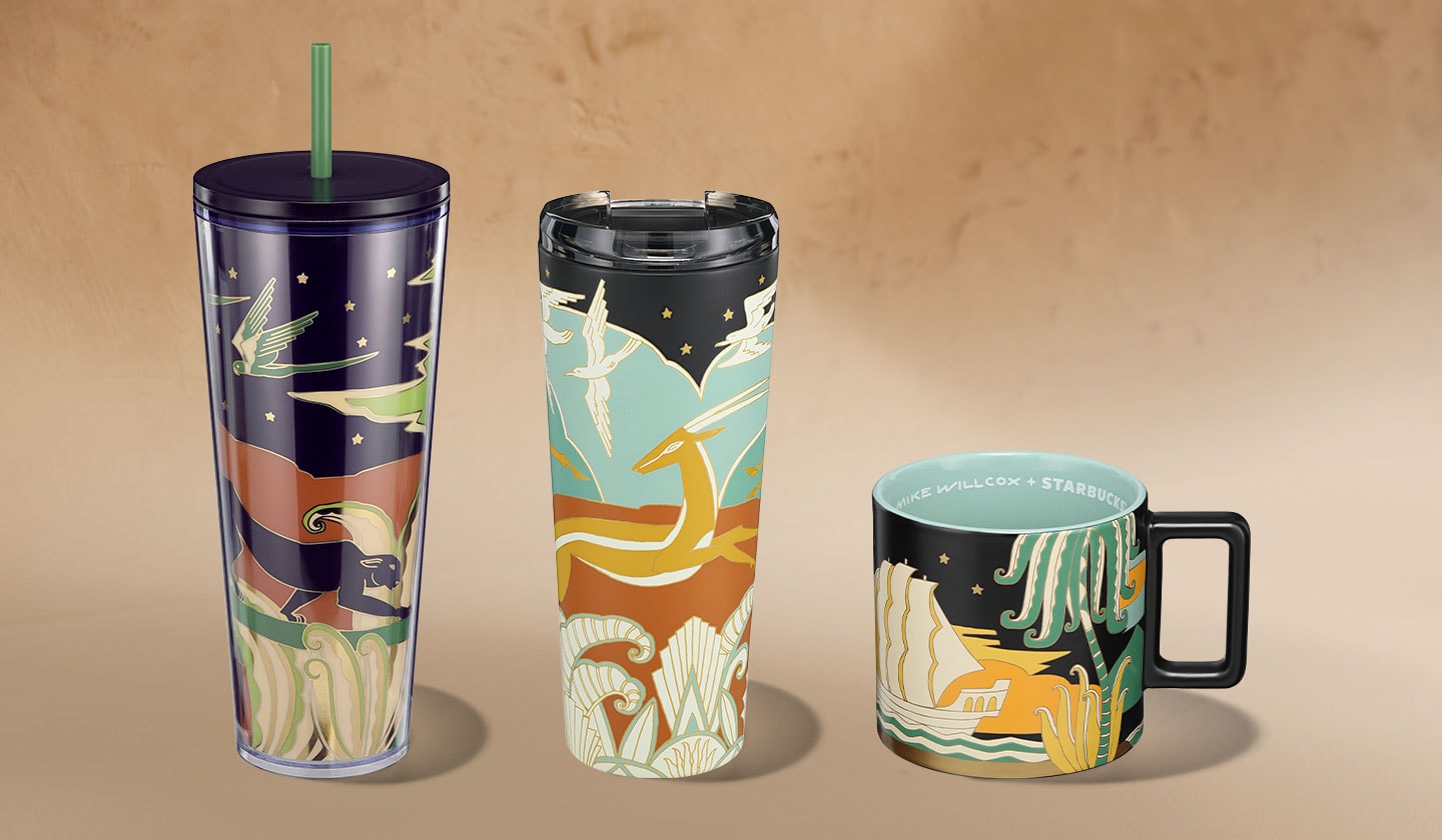 A cold cup with a green straw, hot drink tumbler and coffee mug. All three feature colorful illustrations of nature and wildlife on black backgrounds.
