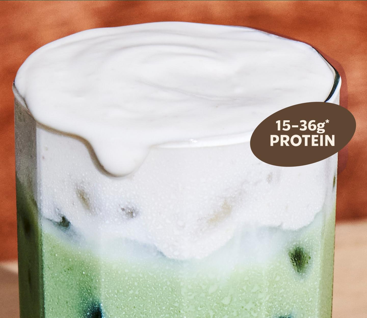 Close up of a glass of iced matcha with a foam top