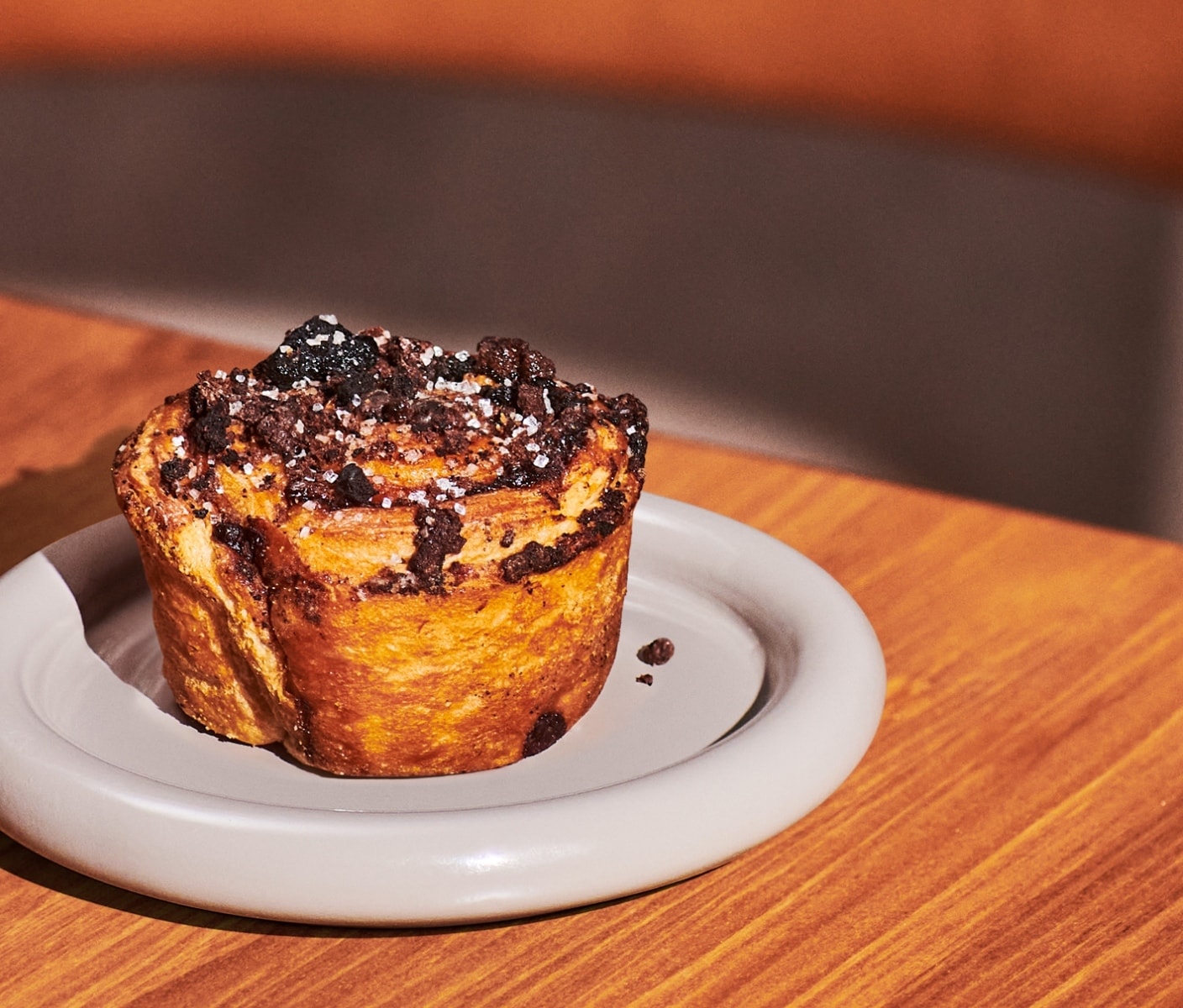 A round pastry topped with crumbles and sprinkles on a round plate.