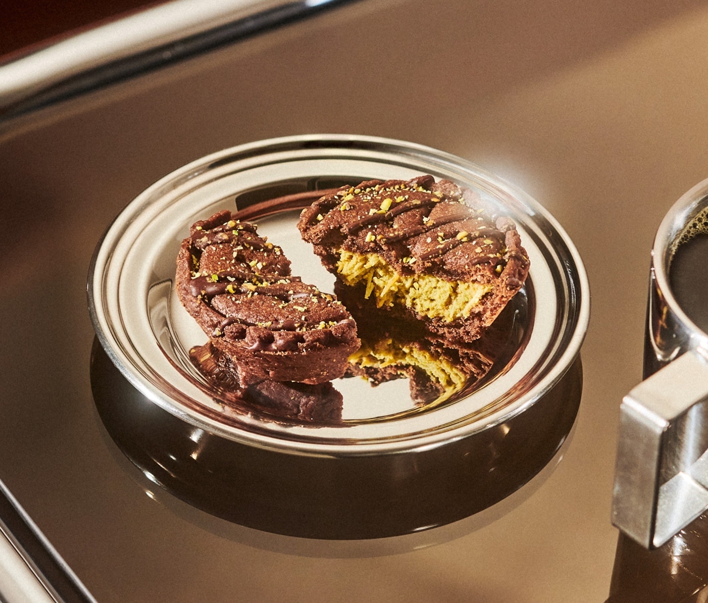 Two halves of a tart with a creamy filling and nuts and drizzle topping on a plate.