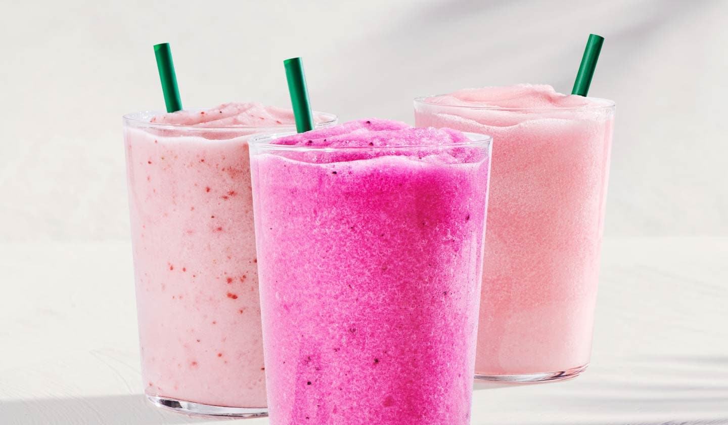 Three Blended Energy Refreshers in glasses with green straws on a white background.