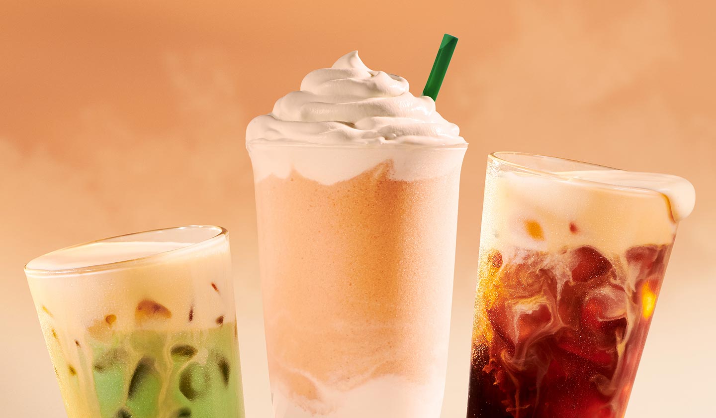 An Iced Orange Cream Matcha, an Orange Cream Frappuccino® Drink with whipped cream on top, and an Orange Cream Cold Brew displayed in a fan shape.