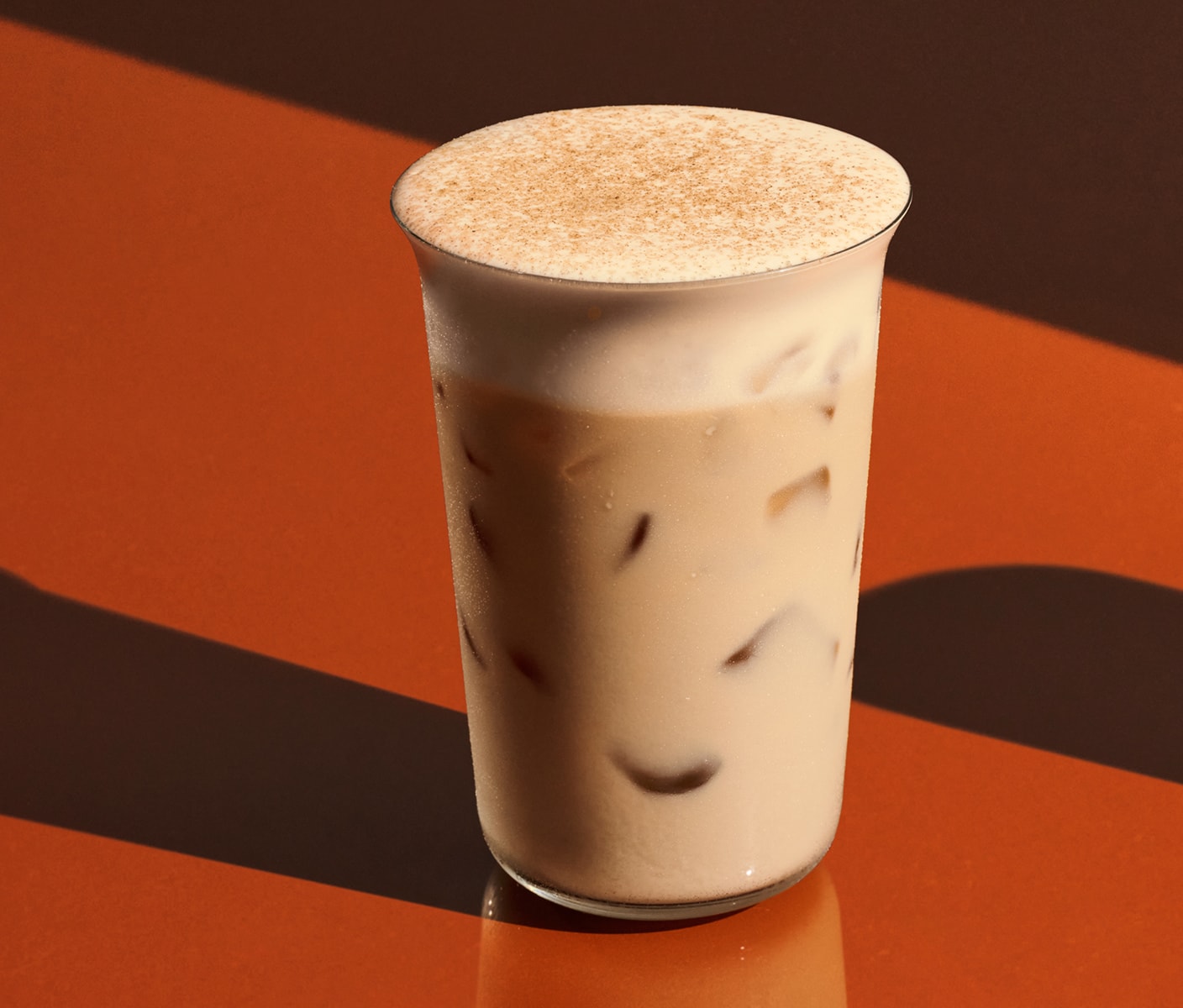 An iced chai with pumpkin cream cold foam and spices.