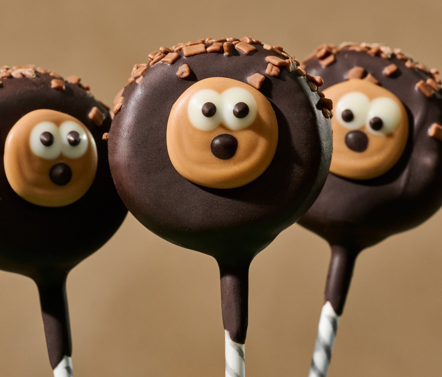 Three chocolate cake pops decorated to look like hedgehogs.