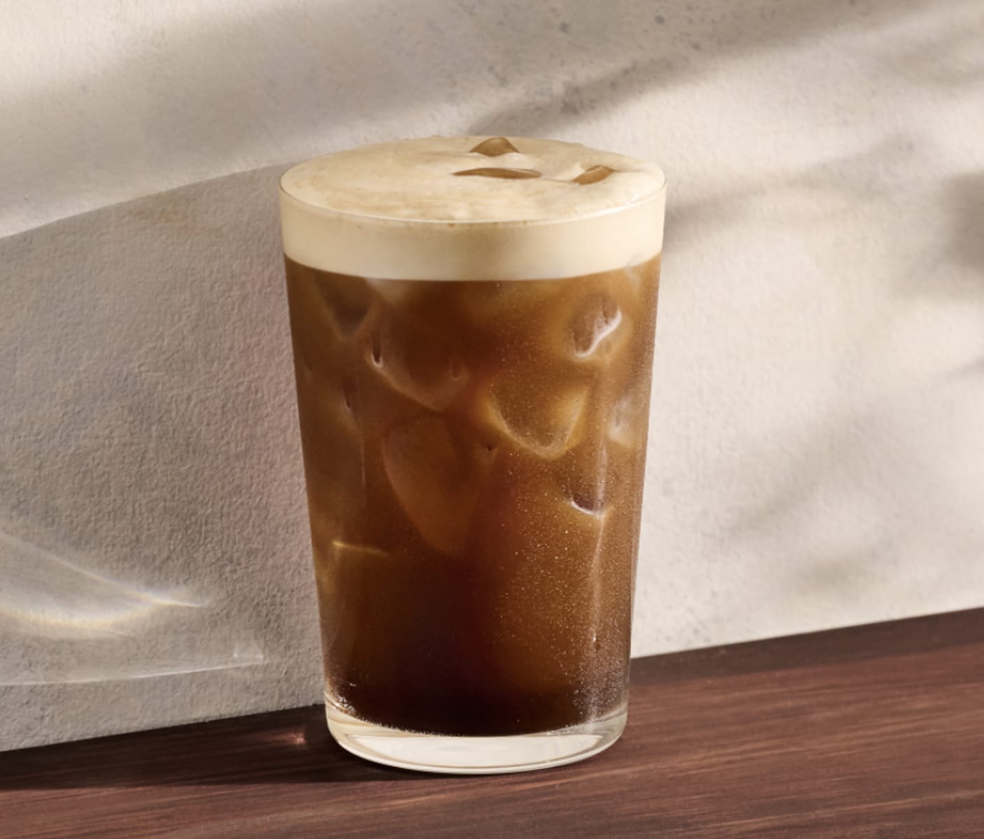 An Aerocano in a tall glass with ice. A light layer of foam rests at the top and deepens into bold espresso toward the bottom.