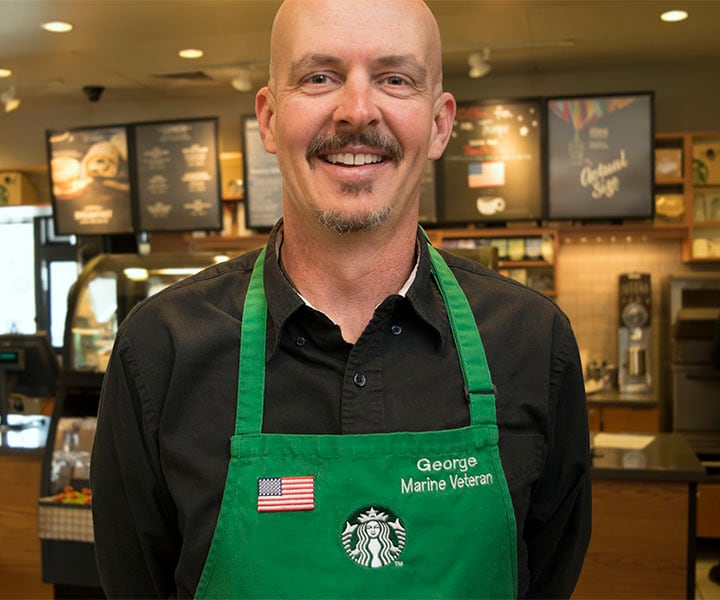 Marine veteran wearing a Starbucks green apron with American flag embroidery