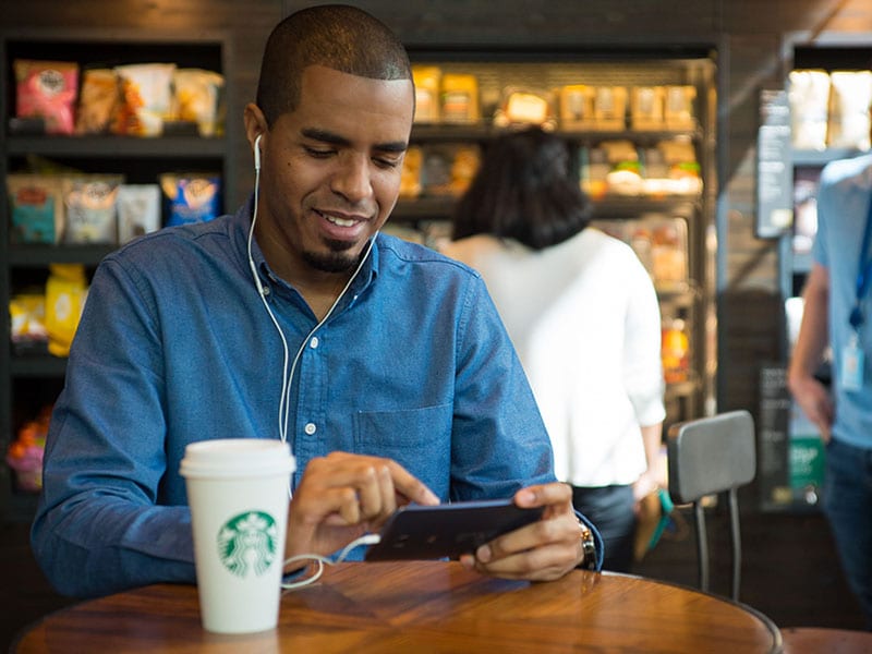 Customer wearing headphones and using smart phone