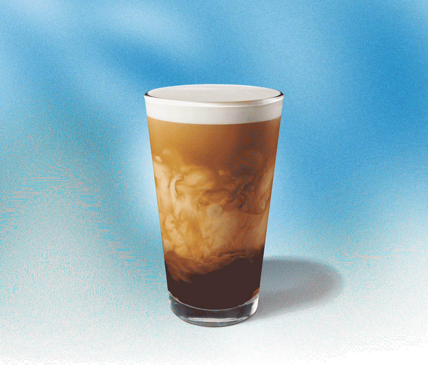 Tall glass of cold coffee with creamy swirls