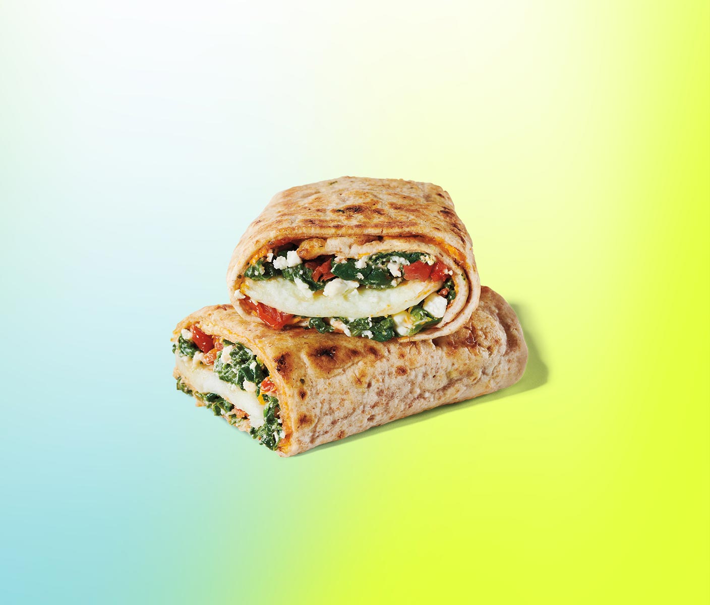 Breakfast wrap sliced in half and stacked, revealing layered ingredients.