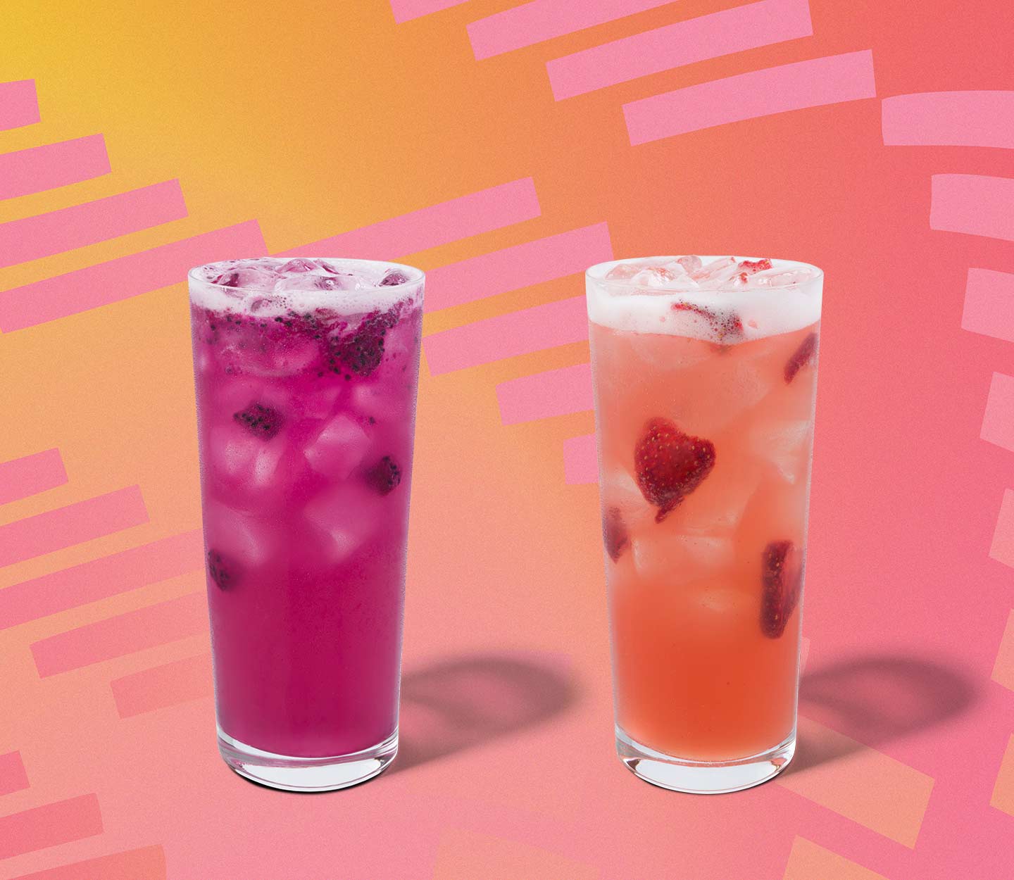 Two colorful iced drinks with fruit inclusions in tall glasses.