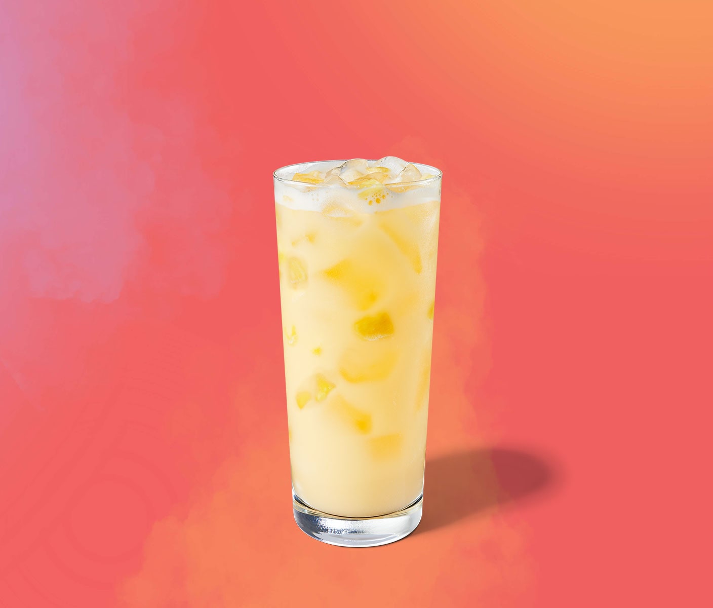 Creamy yellow iced drink with pineapple inclusions in a tall glass.