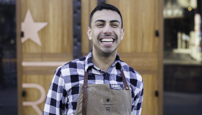 Man wearing Starbucks apron smiling