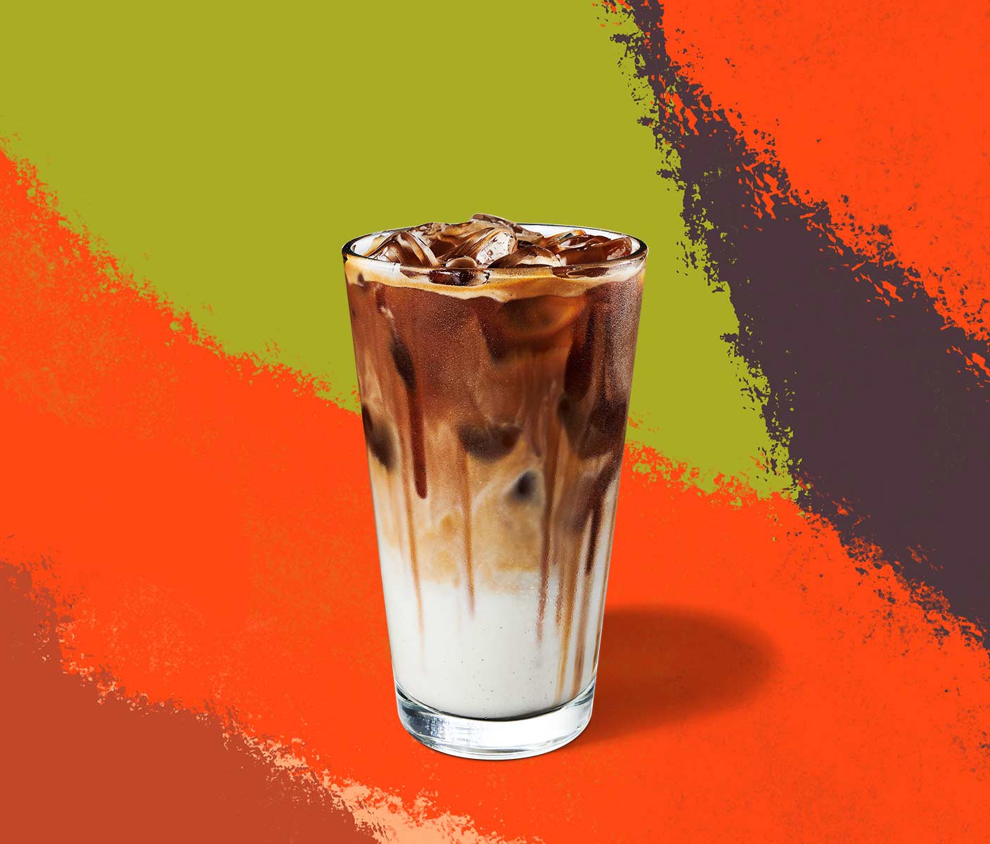 Iced coffee drink with a dark top layer and milky bottom layer inside a tall glass.