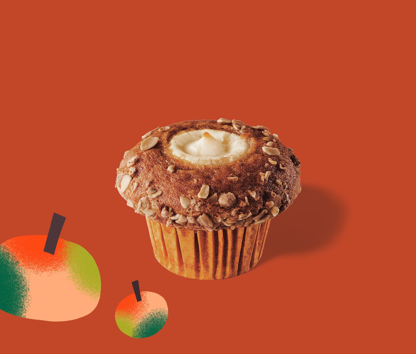 Muffin with cream cheese center next to two graphic pumpkins.