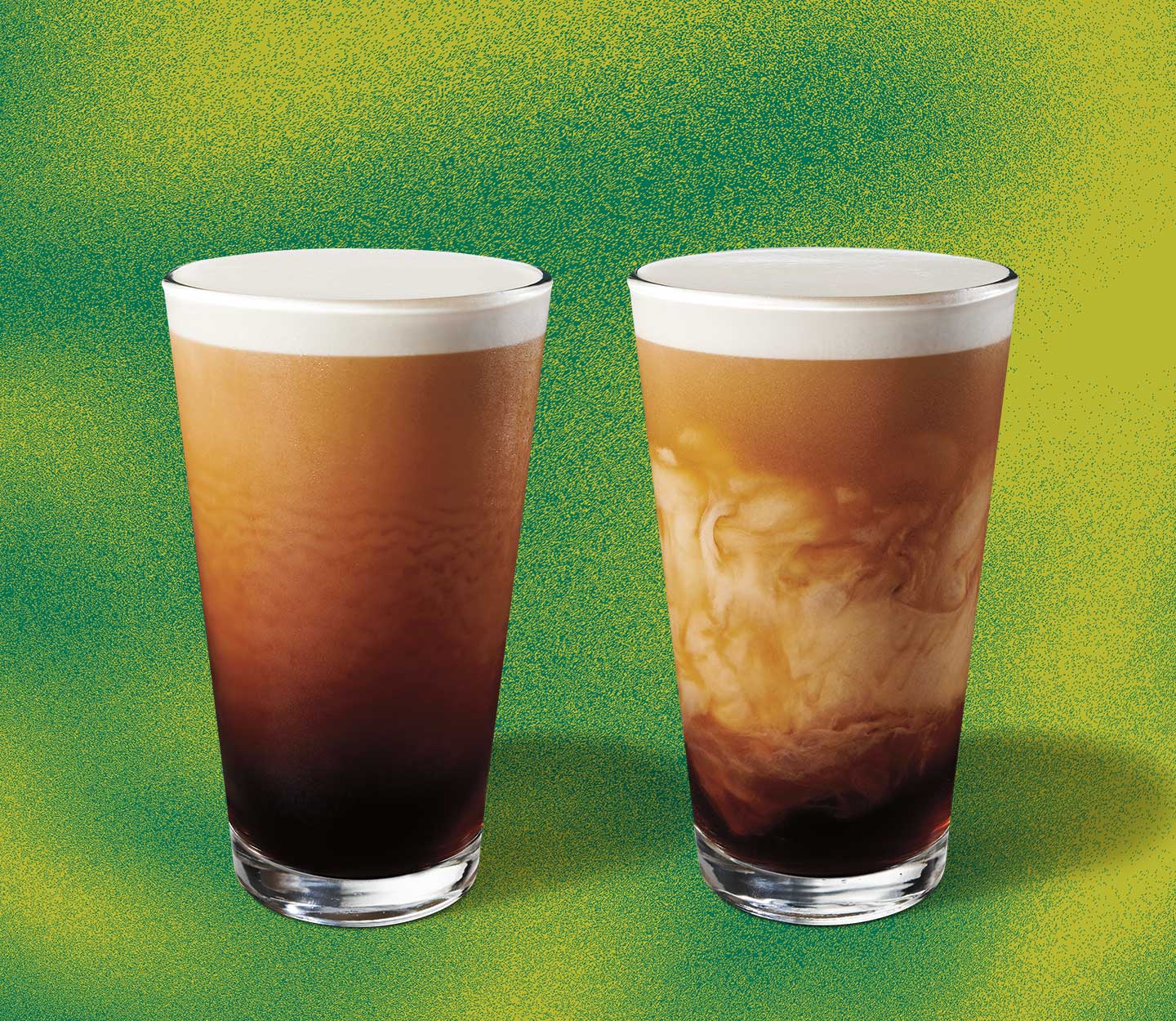 Two cold coffee drinks with frothy tops in tall, clear glasses. The one on the right shows creamy marbling.