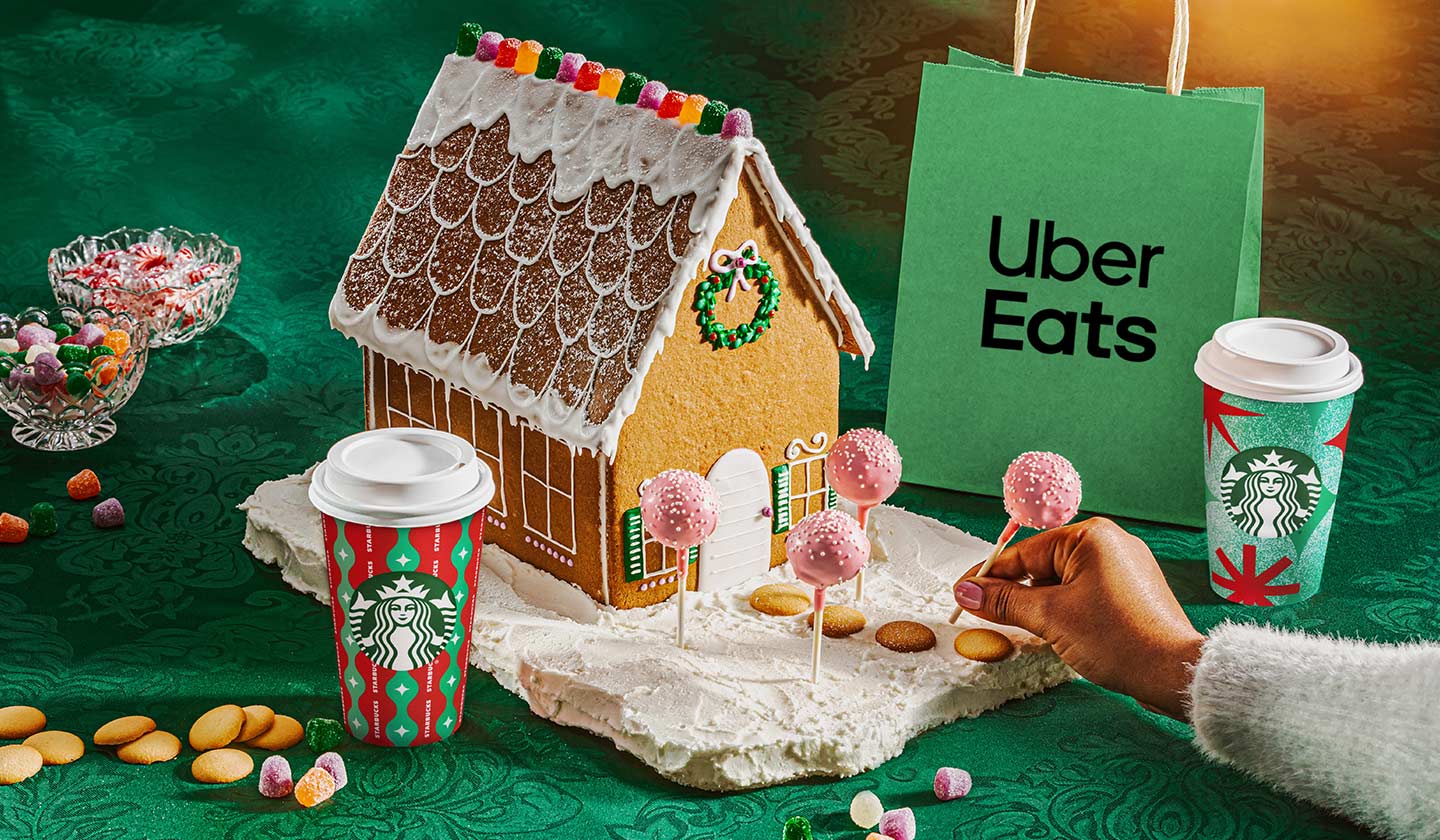 Gingerbread House with Starbucks Coffee Cups and an Uber Eats bag.