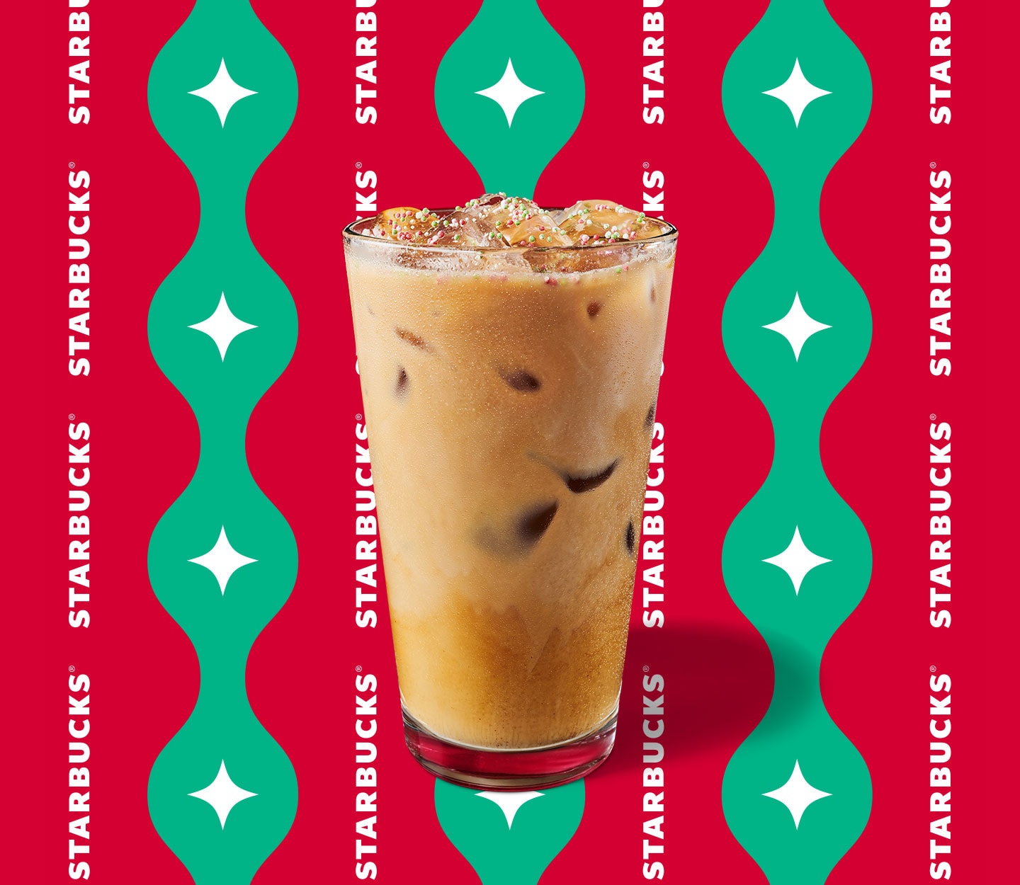Creamy iced espresso drink with red and green sprinkles in a tall glass.