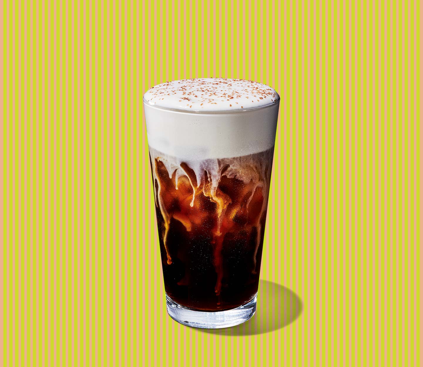 Coffee drink in a tall glass with thick layer of foam on top.