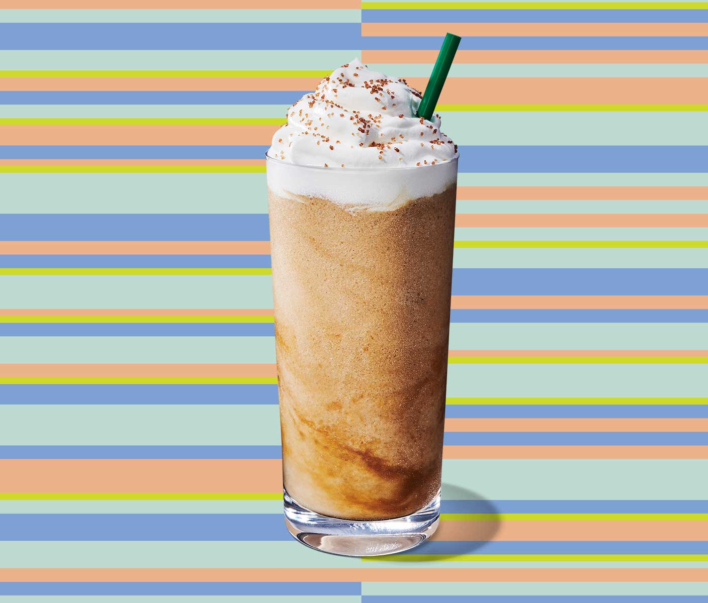 Blended coffee drink in a tall glass with whip cream topping and a straw visible.