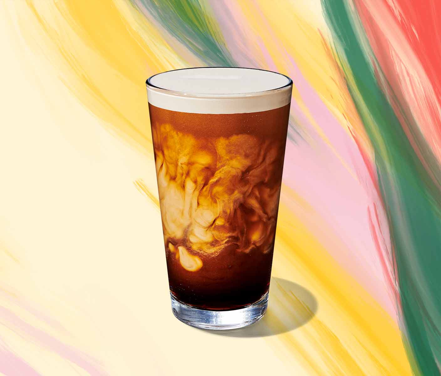 Cold coffee drink with swirls of cream in a tall glass.