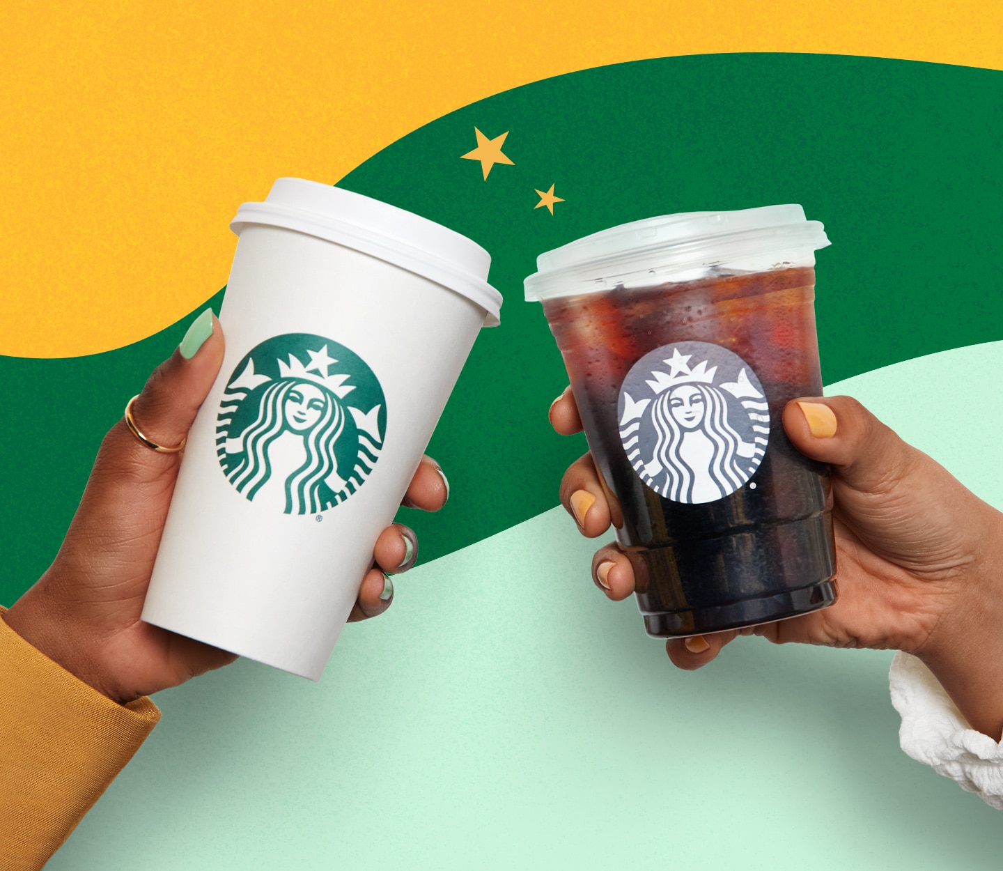 Two hands cheering with one hot and one cold Starbucks to-go cup in each hand while in front of a multi-colored wave.