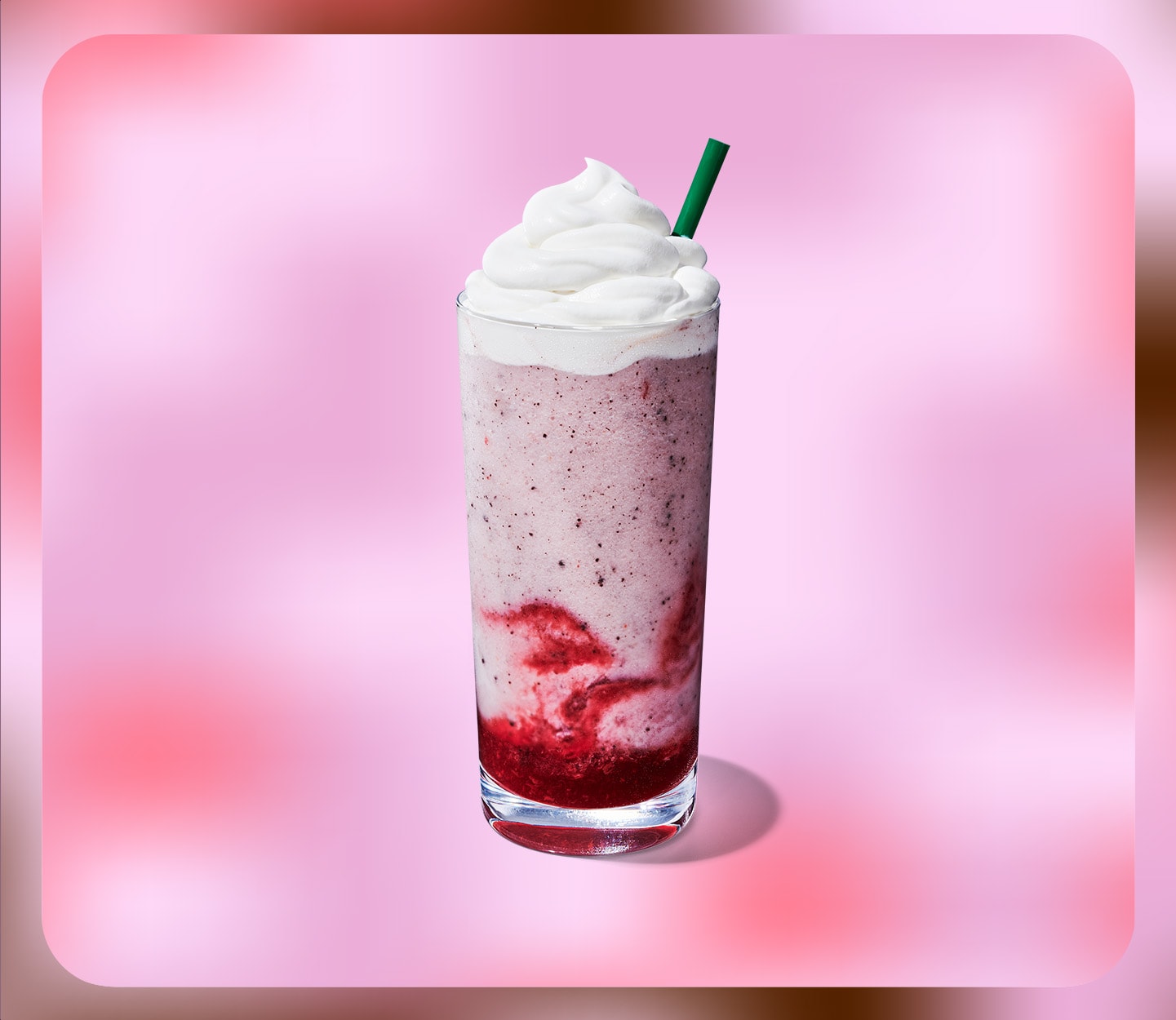 Light-pink blended drink topped with whipped cream.