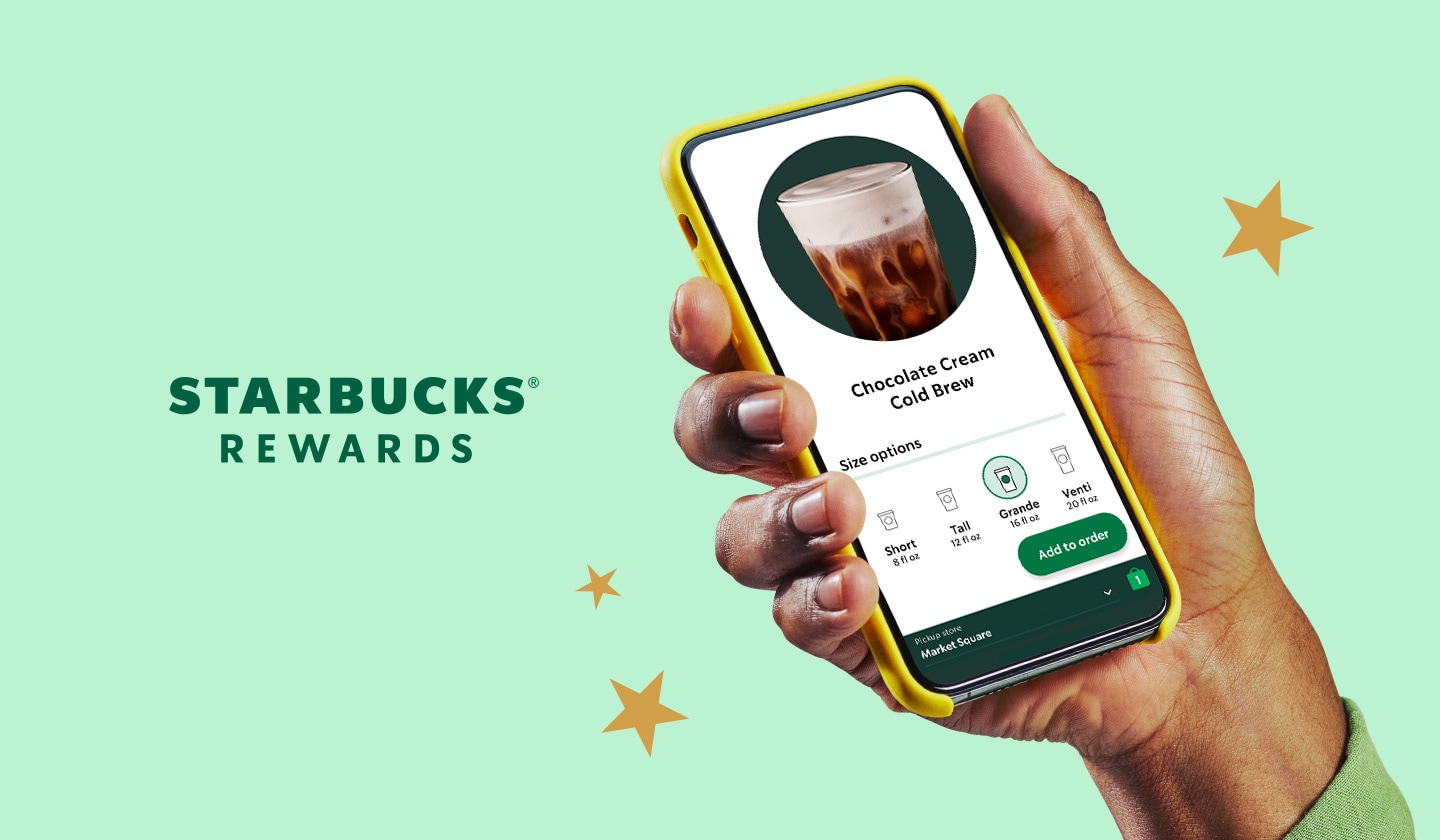 A hand holding a phone showing an in app coffee drink.