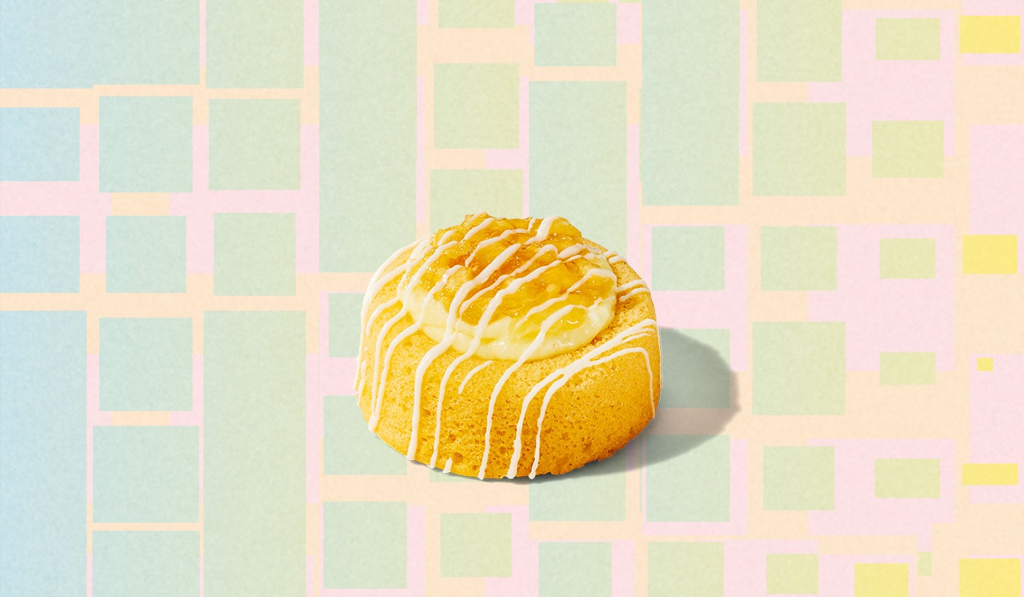 A round, cake-like pastry with a white frosting drizzled on top.