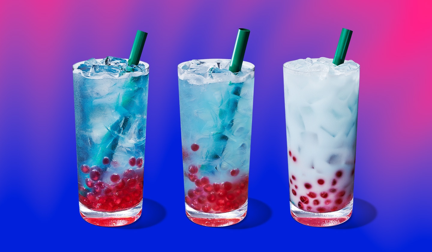 Three iced drinks in varying shades of bright blue, with pink pearls resting at the bottom of the glasses. 