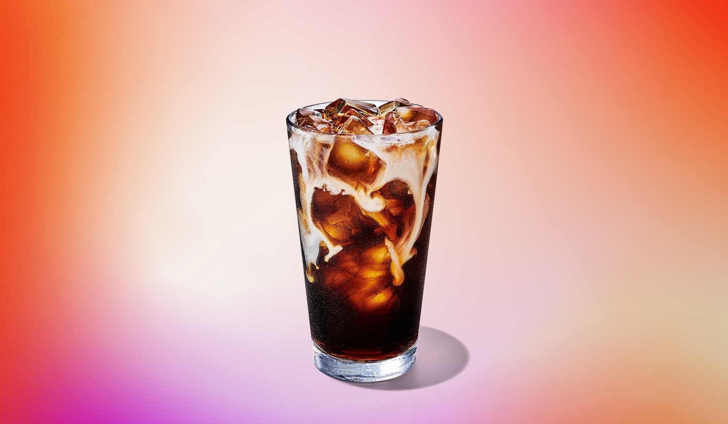 An iced coffee drink with cream swirling through it.