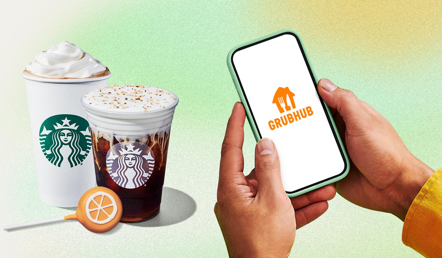 Hands holding phone with Grubhub logo on white screen. Starbucks® food and drink can be seen in background.