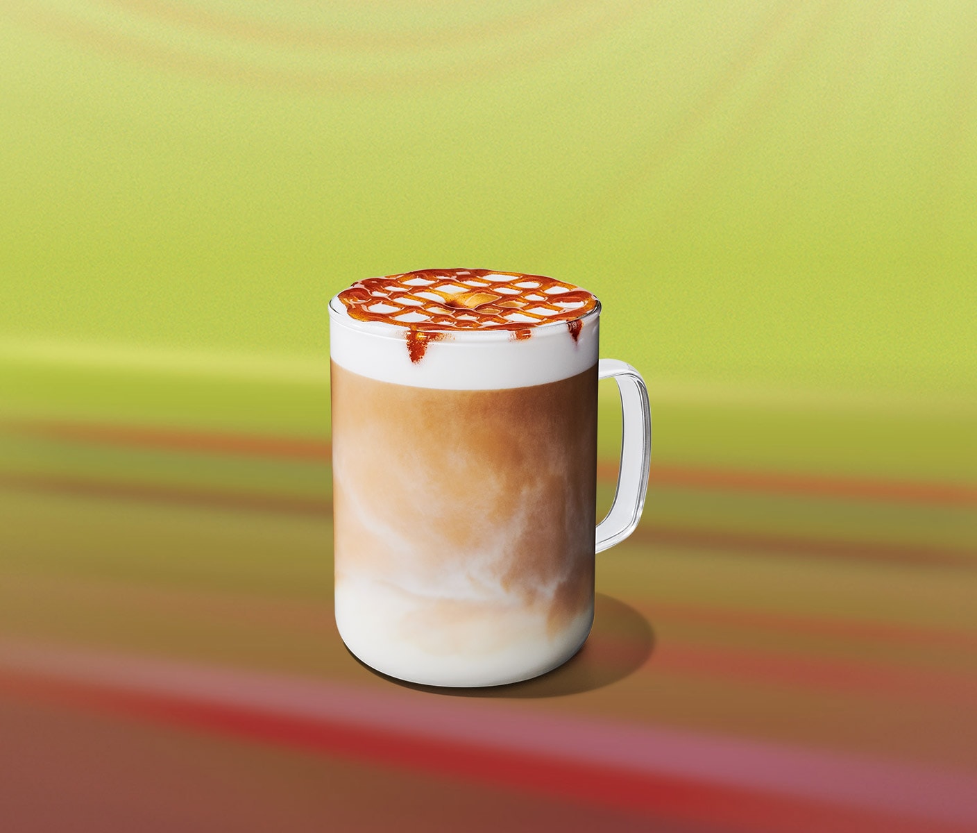 A creamy hot coffee drink with a foam and drizzle in a glass mug.