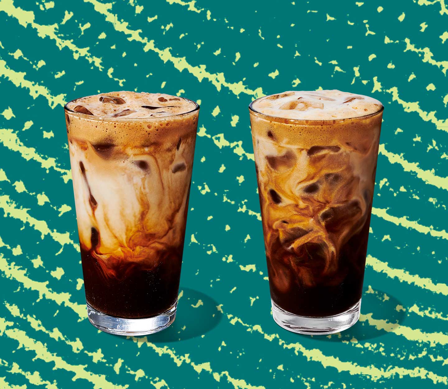 Two iced coffee drinks in tall glasses with creamy marbling throughout.