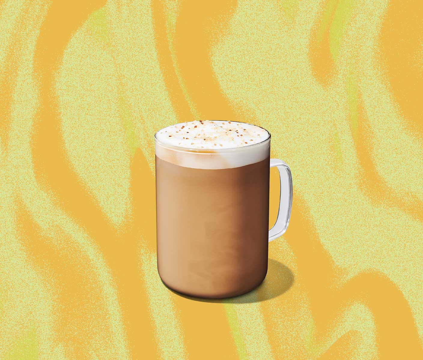 A creamy hot coffee drink with a frothy top in a glass mug.