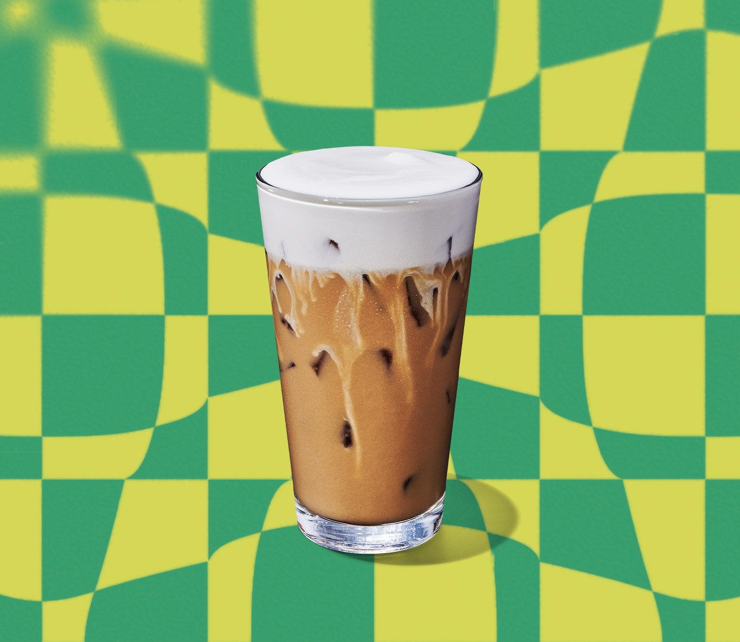 A creamy iced coffee drink with a thick, foamy top in a tall glass.