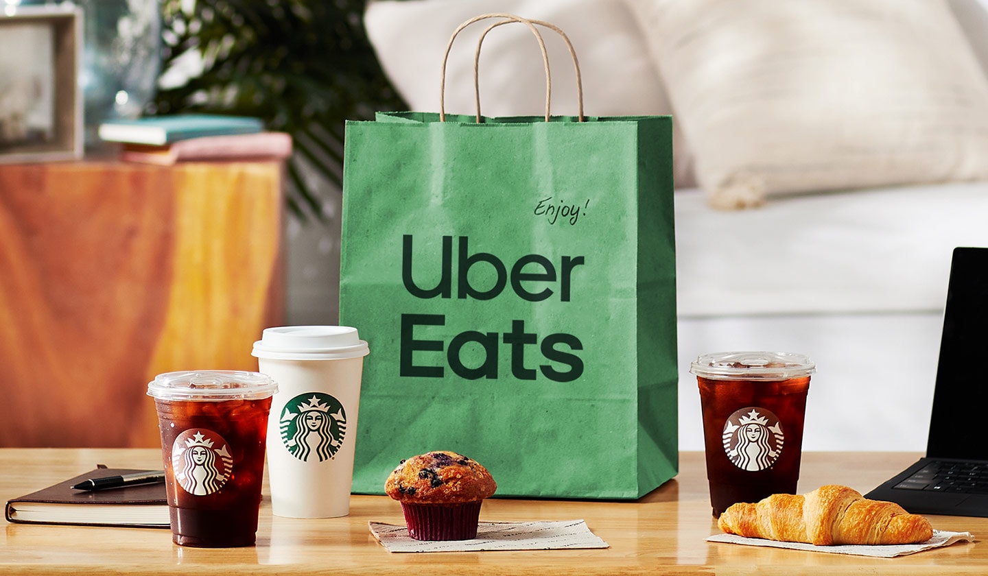 Food and beverages next to a green bag that says Uber Eats