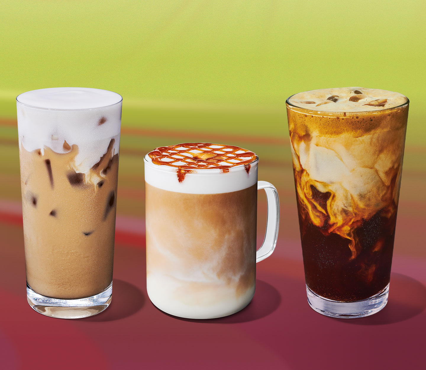 An iced creamy tea drink with a foamy top in a glass, a hot creamy coffee drink with a foam and drizzle in a glass mug and an iced coffee drink with creamy marbling in a glass.