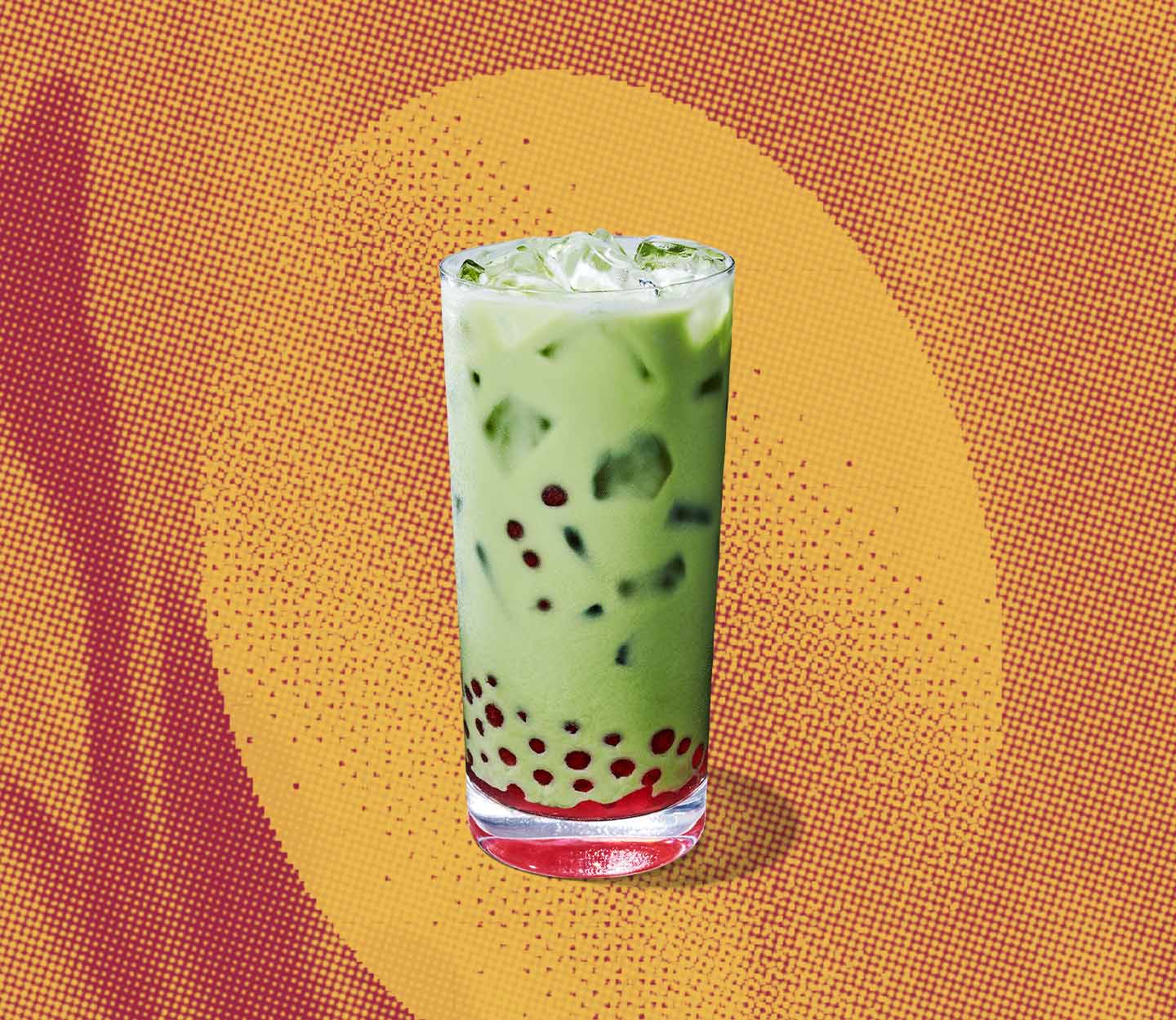 A tall creamy iced green tea drink with red pearls in the center and bottom of glass.