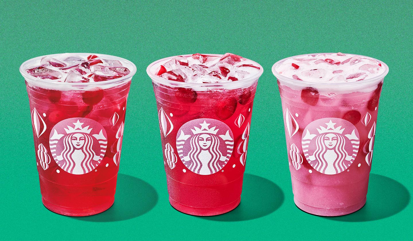 Three iced drinks in varying shades of red and pink with floating pieces of cranberry.