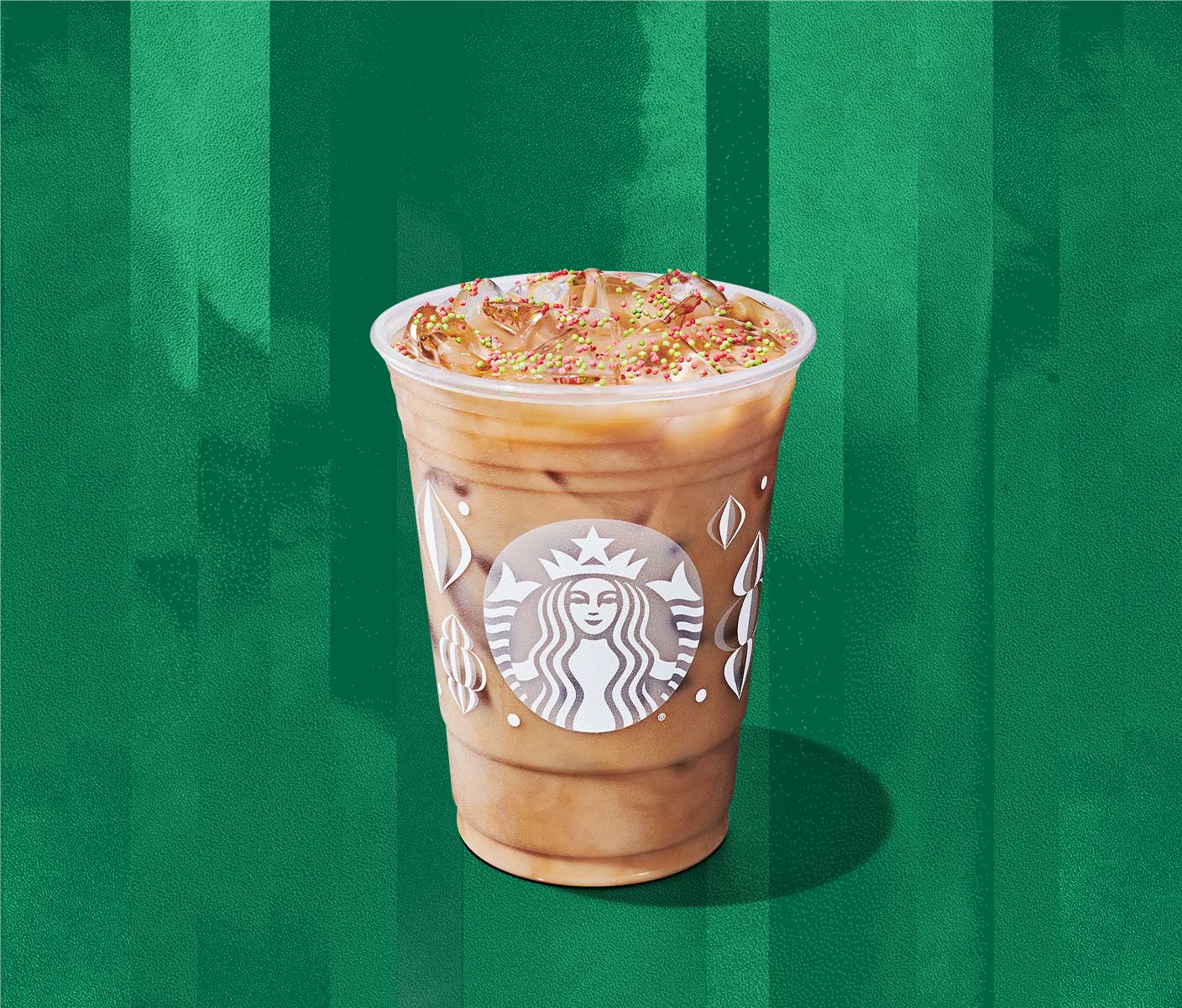 An iced creamy coffee drink with red and green sprinkles on top.