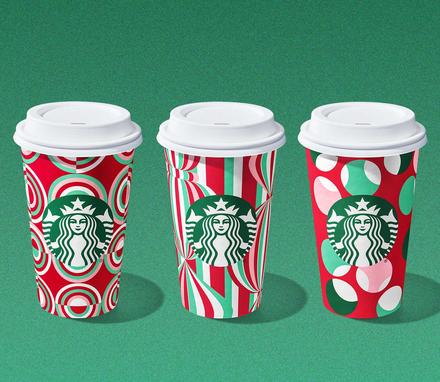 Three hot drinks in festive red and green patterned cups.