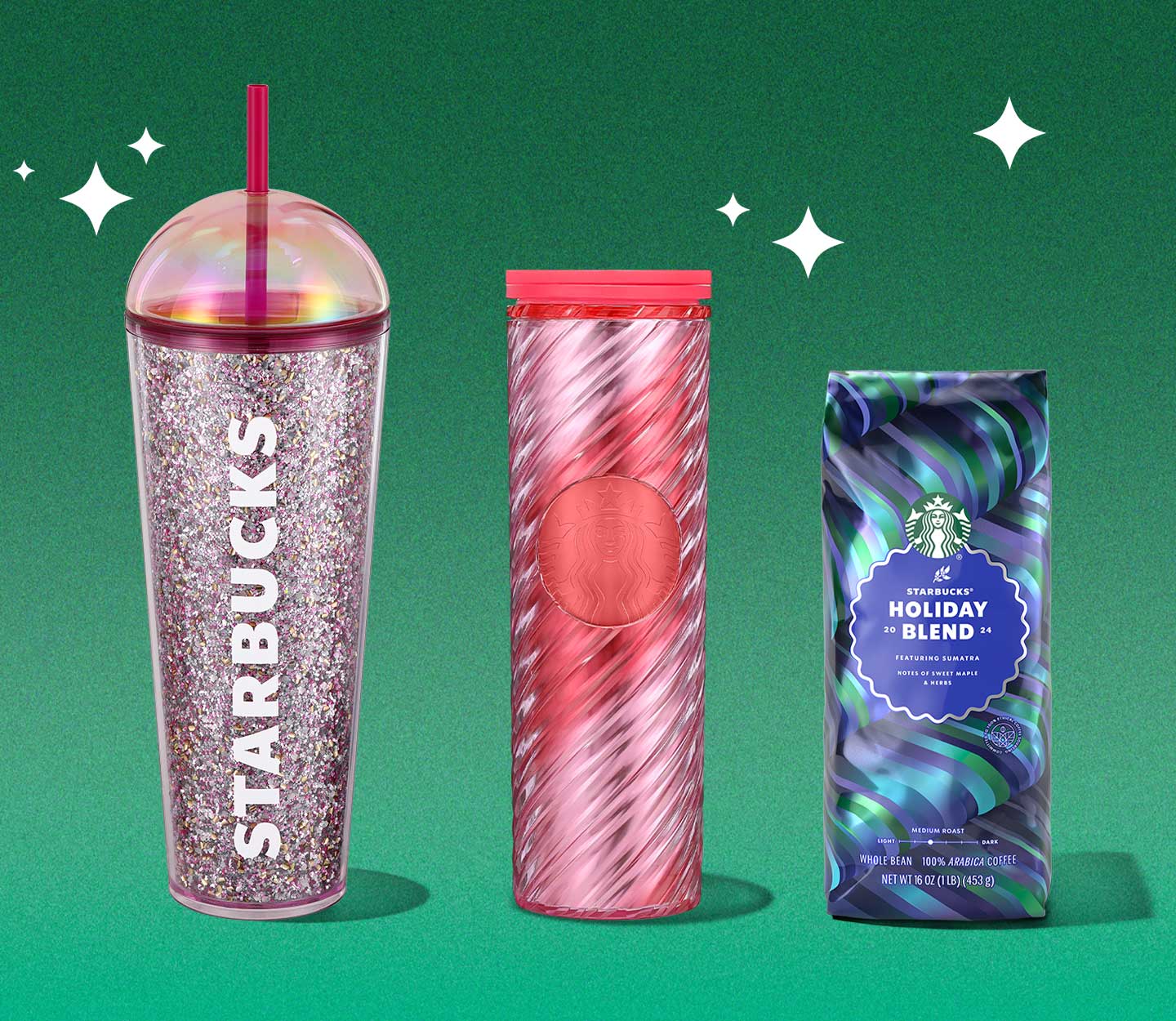 A sparkly personal tumbler with a clear domed lid, a festive red and pink personal tumbler, and a bag of Starbucks Holiday Blend whole bean coffee.