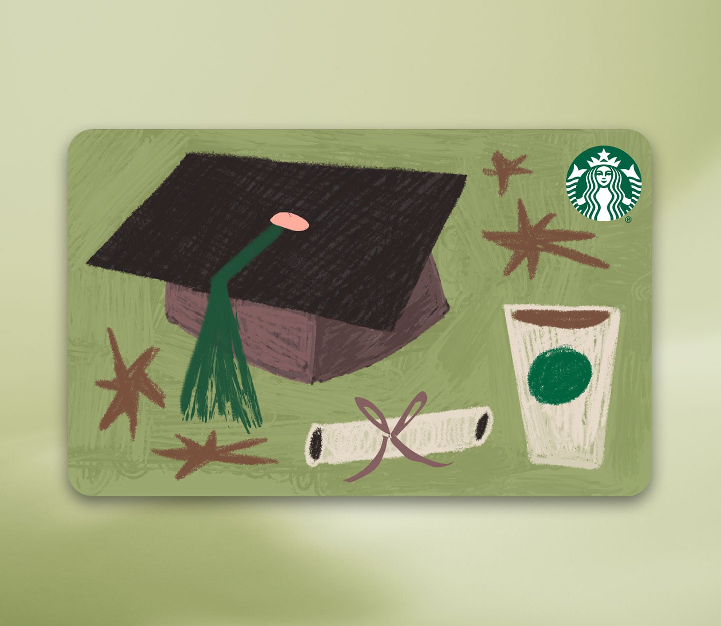 A Starbucks gift card with illustrations of a large graduation cap with green tassel next to a rolled diploma, Starbucks hot cup and Starbucks logo.