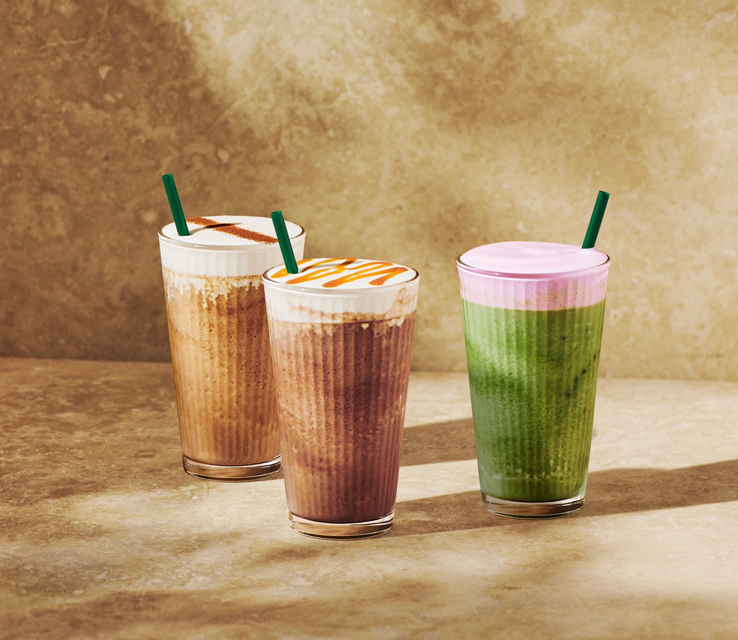 Three different flavors of Strato Frappuccino® Beverages sit on a sun-dappled background.
