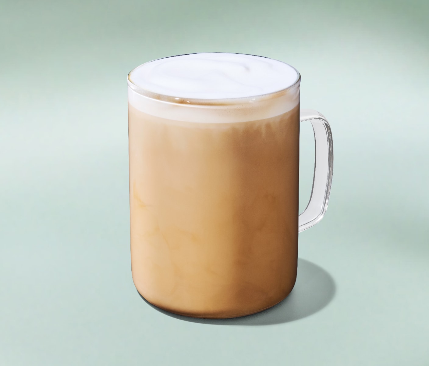 A perfectly steamed latte with a layer of protein milk foam on a minty green background.