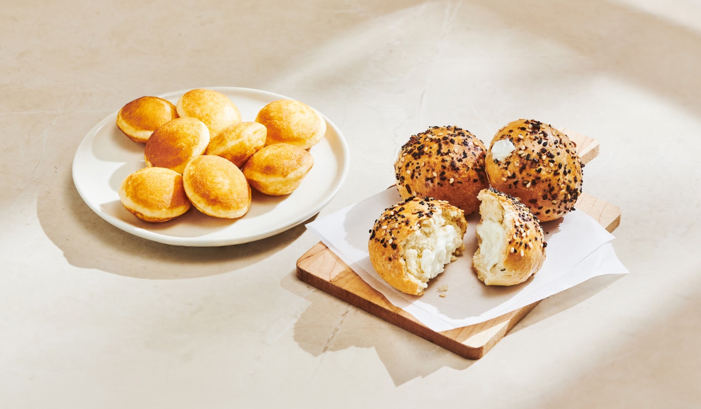 Mini delicious golden pancakes sit on a plate, paired with three savoury mini bagel bites covered in everything bagel seasoning.