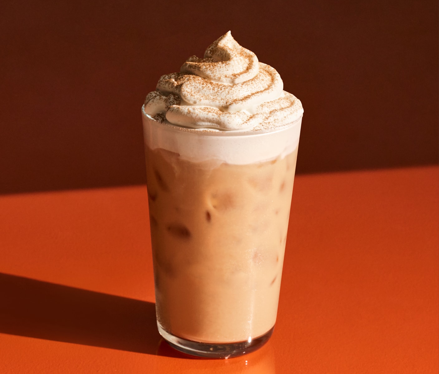 A milky iced coffee drink topped with whipped cream and spices.