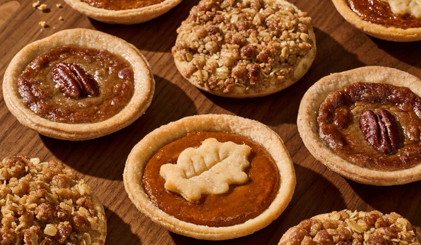A variety of mini pies grouped together on a wood table