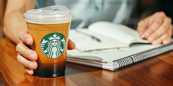 Hand holding Starbucks cold cup without straw