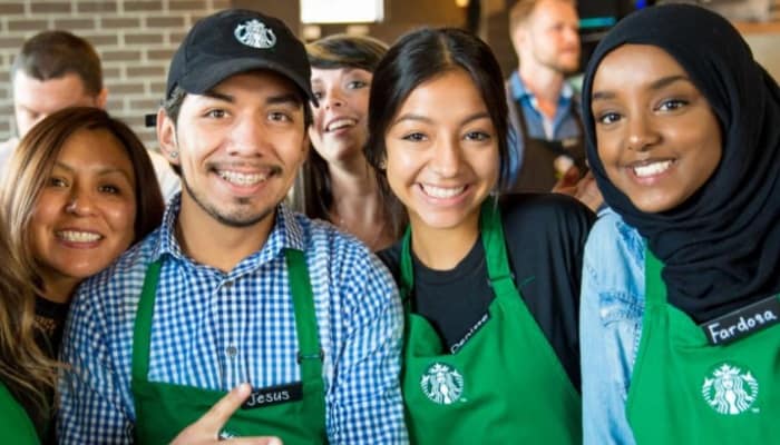 Group of baristas wearing green aprons